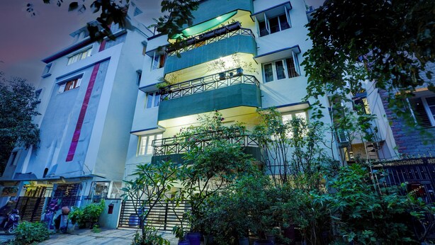 A multi-story building with balconies, a gated entrance, and surrounding greenery. - Alaya Stays Saffron Breeze 4 BHK Apt (Bengaluru)