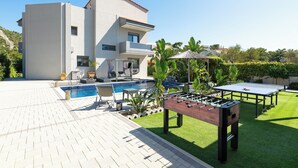 Ett modernt hus med pool, ett fotbollsspel och ett bordtennisbord.