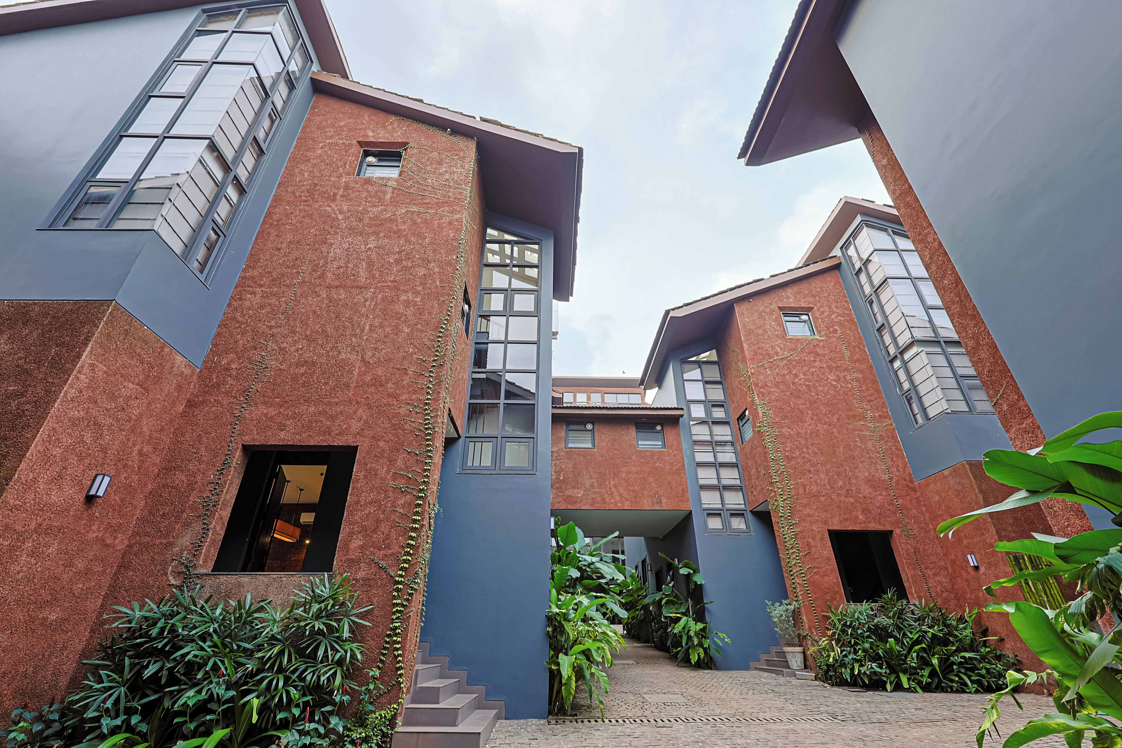 A modern building with a brick facade, large windows, and a central staircase.