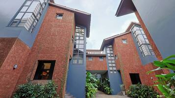 A modern building with a brick facade, large windows, and a central staircase.