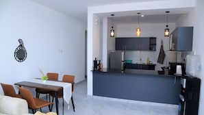 A modern kitchen with grey cabinets, a central island, and pendant lighting.