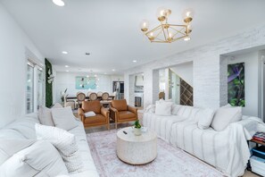 A modern living room with a sofa, armchairs, a coffee table, and a dining area in the background. - THE BAYFRONT HAVEN Private Dock Sauna Pet-Friendly Luxury Destin 30A Retreat (Santa Rosa Beach)