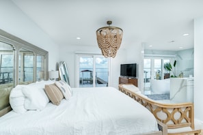 A modern hotel room with a large bed, a television, a balcony with a view of the sea, and a bathroom with a bathtub. - THE BAYFRONT HAVEN Private Dock Sauna Pet-Friendly Luxury Destin 30A Retreat (Santa Rosa Beach)