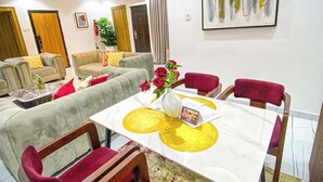 A dining area with a table, chairs, and a hanging light fixture. - THE 81 APARTMENTS (Lagos)