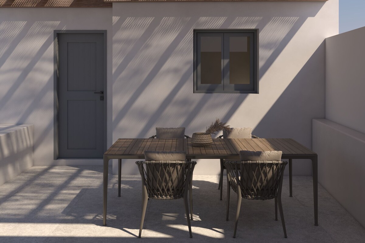 A patio with a table and chairs, a door, and a window.