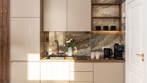 A modern kitchen with a marble backsplash, a built-in coffee station, and a wooden door. - Perfect Old Town Krakow's Architect Apartment AC WiFi King Size Bed Parking (Kraków)