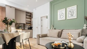 A modern living room with a dining area, a sofa, a coffee table, and artwork on the wall. - Perfect Old Town Krakow's Architect Apartment AC WiFi King Size Bed Parking (Kraków)