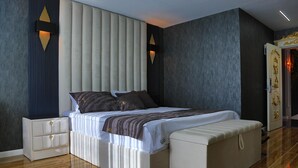 Ein modernes Schlafzimmer mit einem großen Bett, Nachttischen und einem Kleiderschrank.
