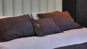 Una cama con ropa de cama blanca y dos almohadas marrones.