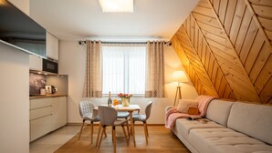 A compact living space with a kitchenette, dining area, and a sofa. - ANAapart (Zakopane)