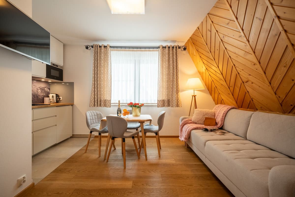A compact living space with a kitchenette, dining area, and a sofa.