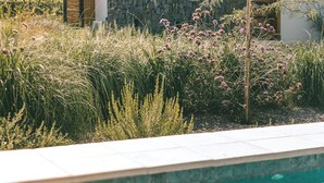 Una casa moderna con fachada de piedra, piscina y vistas a las montañas.