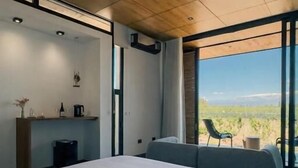 Un dormitorio moderno con una cama grande, un escritorio y vistas al exterior.