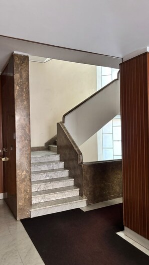 A staircase with a marble finish and a dark wooden handrail. - Vatican Boutique Rooms (Rome)