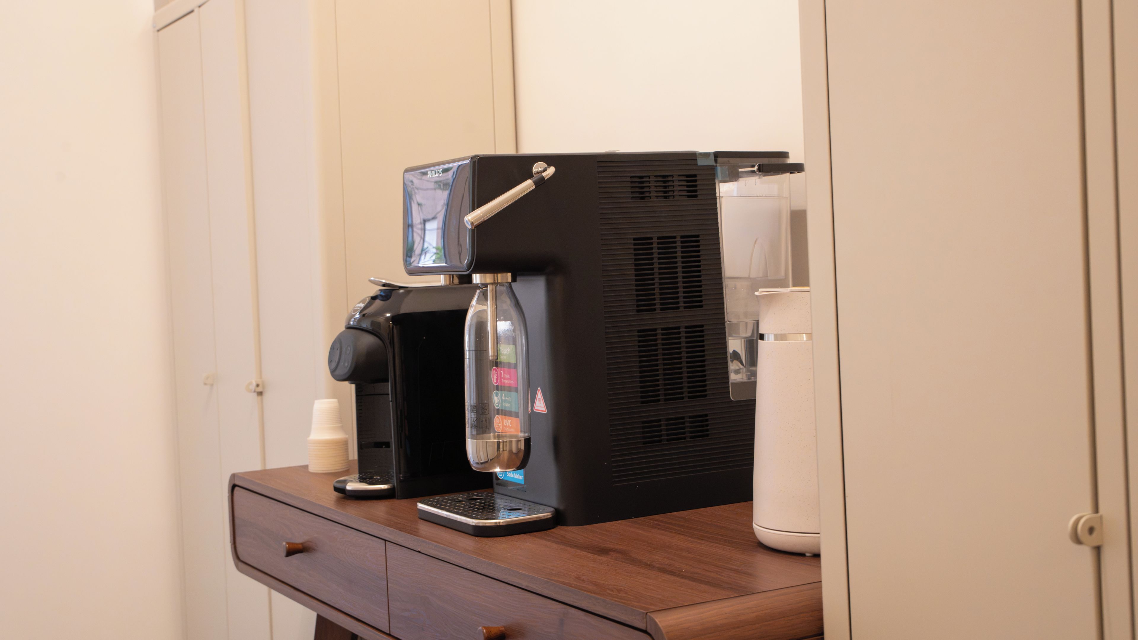 Una macchina da caffè su un bancone di legno con un cassetto sottostante.