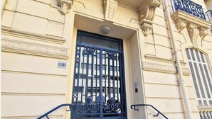 A building facade with a large, ornate metal gate, a sign reading '11 BIS,' and classical architectural details. - N&J - CLOS DES FLEURS - Luminous - Spacious (Nice)