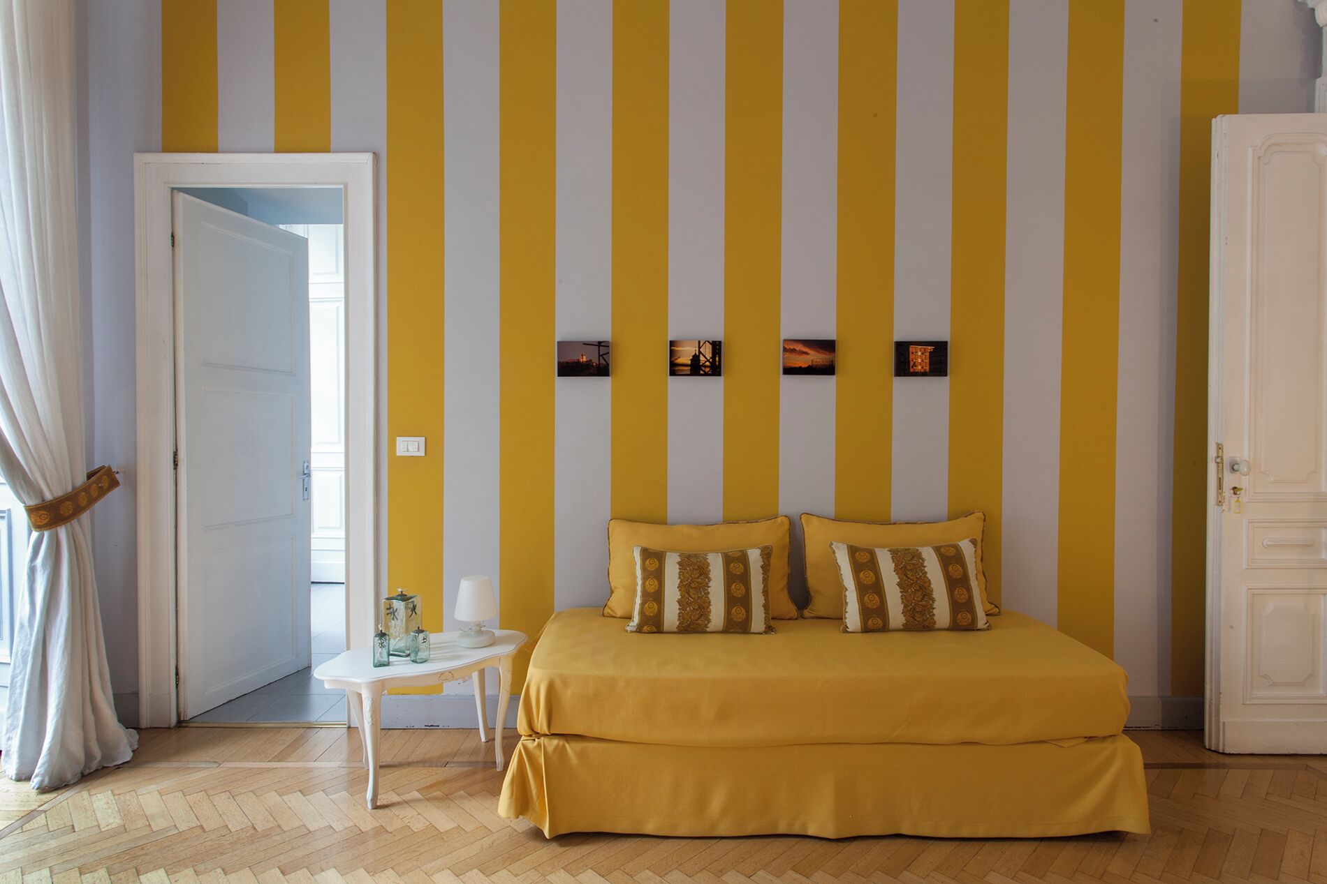 Una habitación con una cama, una mesita y una puerta.