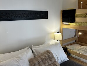 A bunk bed with a television on the upper bunk, a bedside lamp, and a decorative wall piece. - Modern apartment with parking - 8 guests (Arâches-la-Frasse)