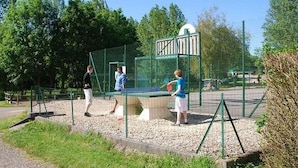 An outdoor tennis court with a net, surrounded by a green fence and trees. - Mobile home, pets welcome - 6 guests (Les Grandes-Ventes)