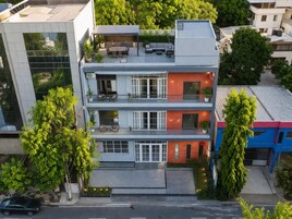 A multi-story building with balconies, large windows, and a rooftop terrace.