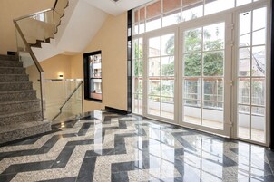 A modern interior with a staircase, large windows, and a patterned floor.