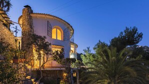 A stone building with a curved facade, a balcony, and a large arched window. - Villa MAGIA by Abahana Villas (Benissa)
