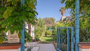 Ein Gartenweg führt zu einem Gebäude, dessen Schild auf einen geschützten Bereich aus Sicherheitsgründen hinweist.