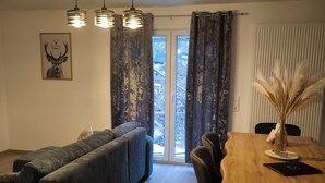 Un salon moderne comprenant un canapé, une table à manger, des chaises et un ventilateur de plafond.