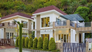 A modern two-story house with a stone facade, large windows, and a balcony. - ELIVAAS Serenita Abode Tranquil Escape (Bagradhauran)