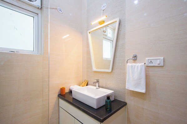 A bathroom with a white sink, a mirror, a towel, and a window.