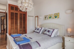 A bedroom with a bed, a nightstand, a mirror, and a wall with artwork. - Neptuno 3: Stunning apartment with sea views in Port de Soller with A/C (Port de Sóller)