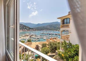 A balcony with a view of a marina, buildings, and mountains. - Neptuno 3: Stunning apartment with sea views in Port de Soller with A/C (Port de Sóller)