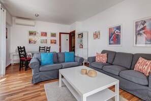 A modern living room with grey sofas, a white coffee table, and artwork on the walls. - Neptuno 3: Stunning apartment with sea views in Port de Soller with A/C (Port de Sóller)