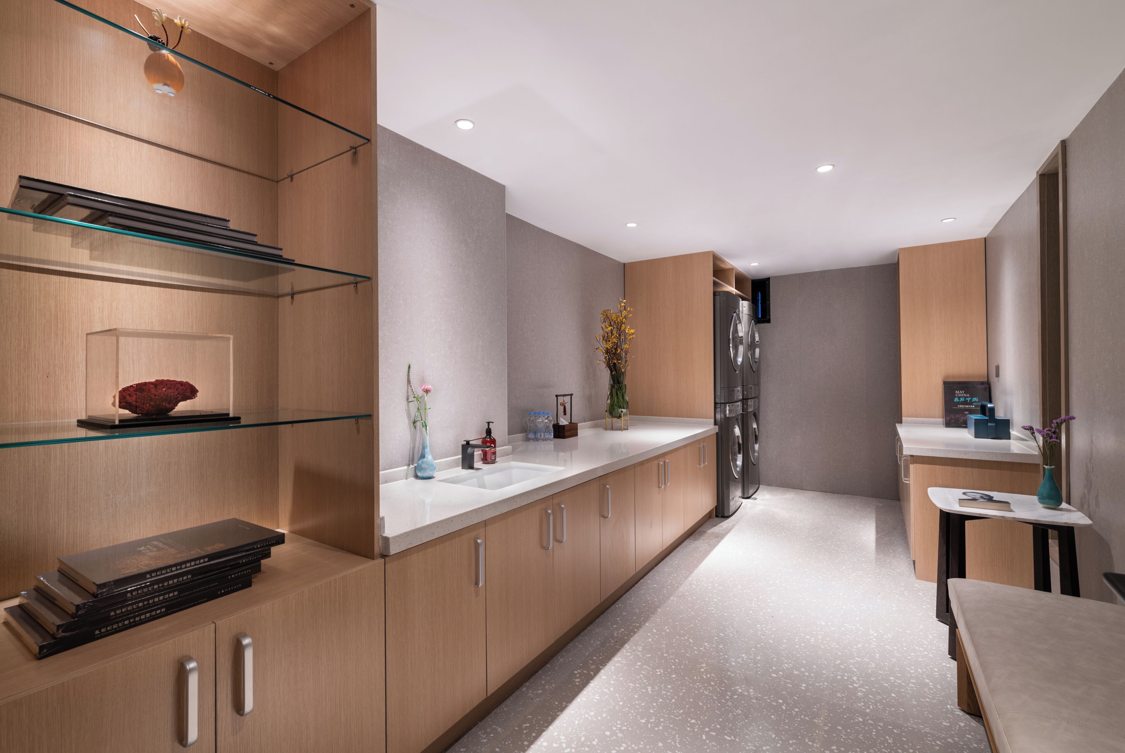 Eine moderne Küche mit Holzschränken, einer Glastrennwand und einem Edelstahlkühlschrank.