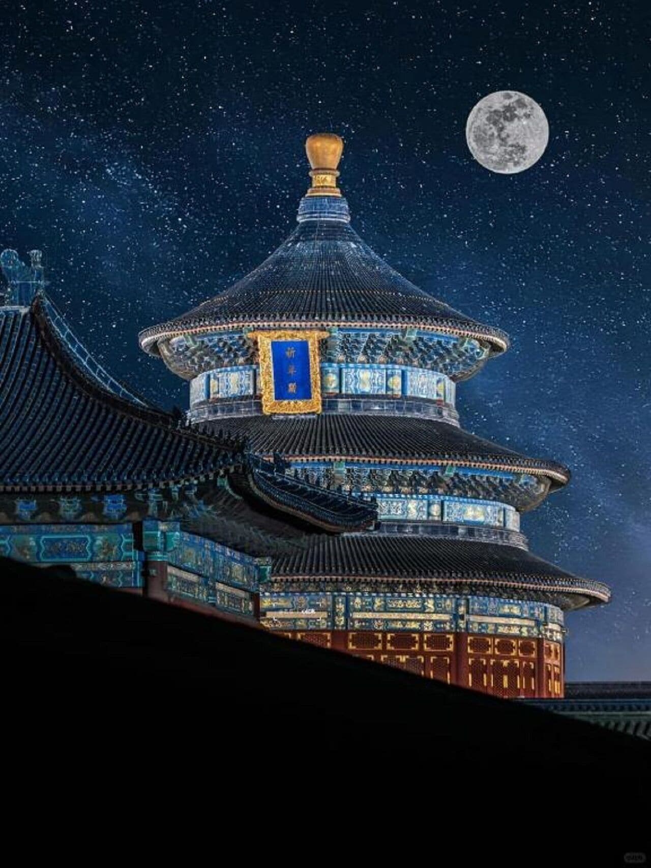 Un edificio tradicional de varios niveles con un llamativo esquema de color azul y dorado, bajo un cielo nocturno con luna visible.