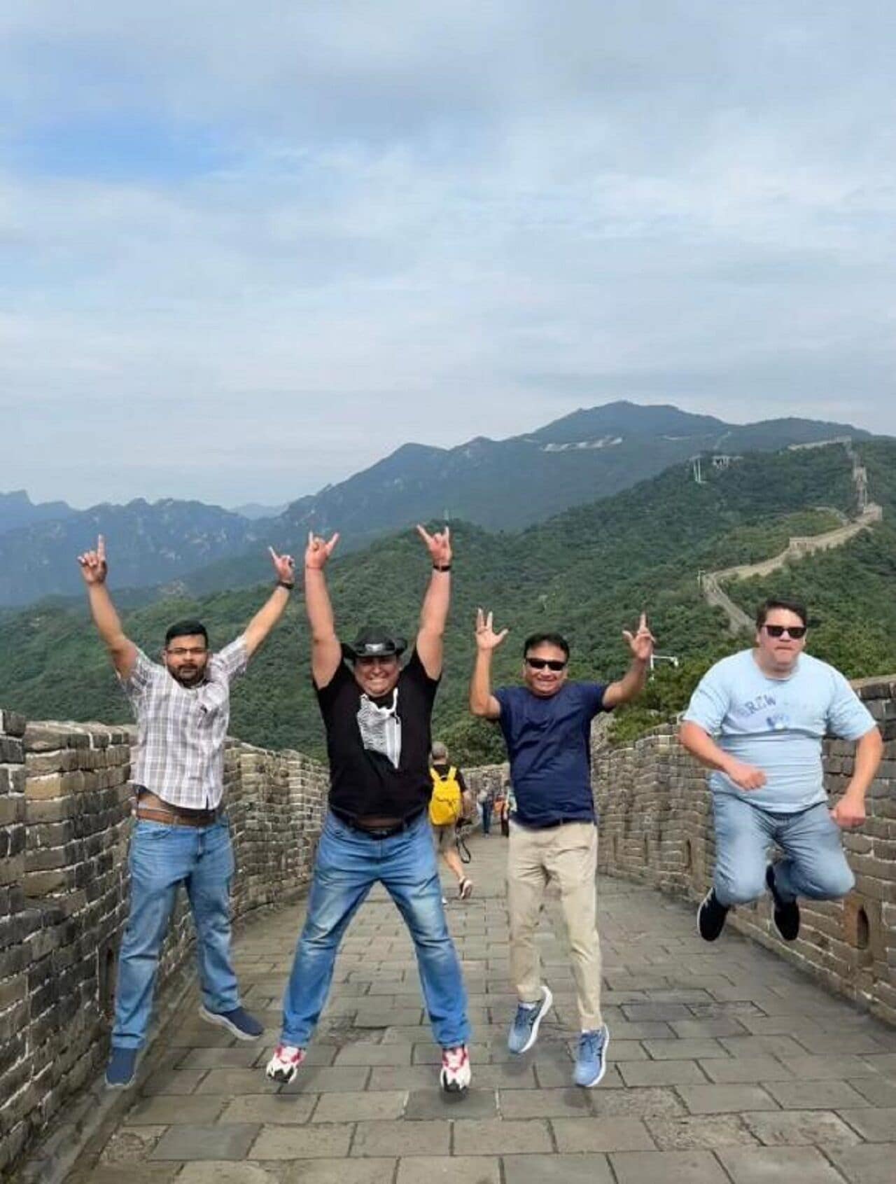A group of people on a stone pathway with a mountainous backdrop.