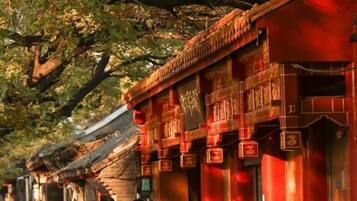 A traditional building with a red facade, a tiled roof, and a stone base.