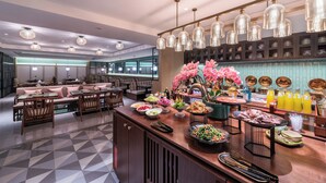 Un restaurante moderno con barra central, zona de estar y elementos decorativos como flores y botellas.