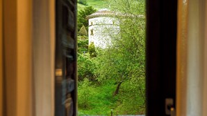 A view through a doorway of a building with a circular structure and a lush green landscape.