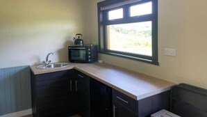 A kitchen with a window, a sink, and a microwave. - Craigengillan Mini Lodge (Dalmellington)