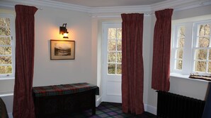 A room with a bench, a radiator, and a window with curtains. - Find Me Out - Craigengillan Estate (Dalmellington)