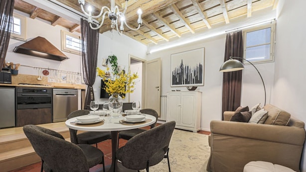 A modern kitchen with a dining area, a sofa, and a chandelier. - Apartments Florence - Mezzo Boutique Vista (Firenze)