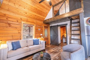 A wooden interior with a sofa, armchair, and a staircase. - Treetopia Ridge - A Rare Find among 1 Bedroom Cabins - Master Suite +Children's Loft +Guest Quarters (Sevierville)