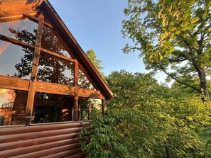 A wooden cabin with large windows and a log exterior. - Treetopia Ridge - A Rare Find among 1 Bedroom Cabins - Master Suite +Children's Loft +Guest Quarters (Sevierville)