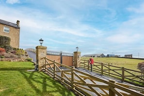A cottage entrance with a wooden gate, stone pillars, and a mailbox. - House Sleeps 12 With Parking and Garden (Newcastle-upon-Tyne)