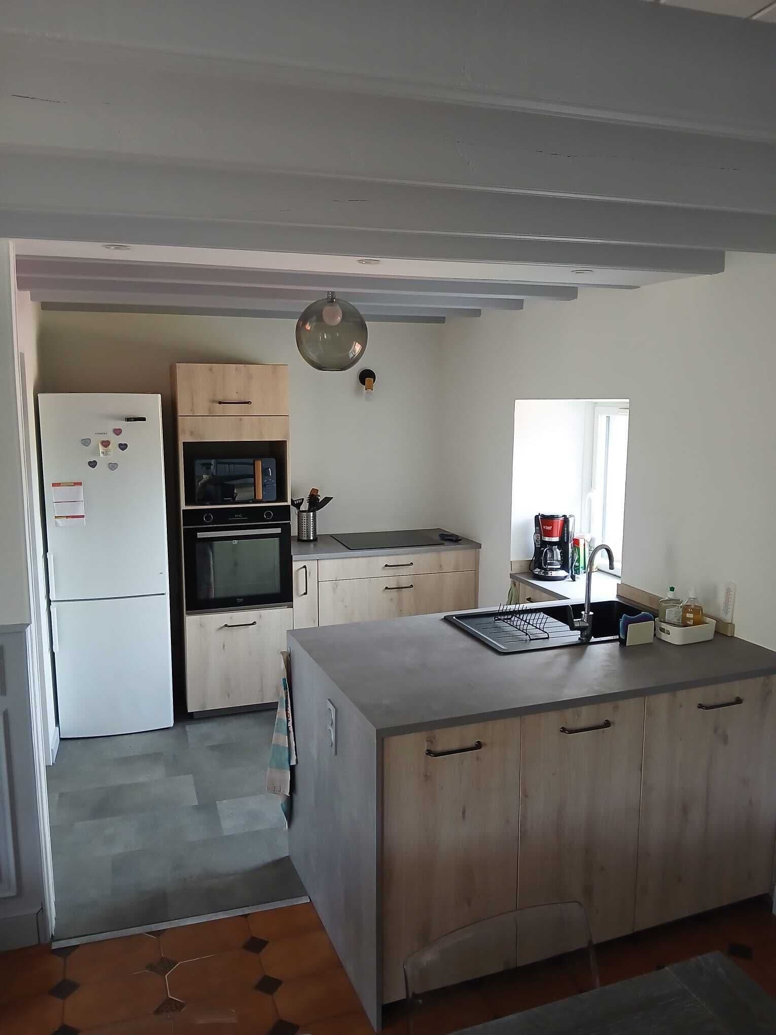 A compact kitchen with a refrigerator, oven, microwave, and a coffee maker on the counter.
