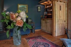 Ein Zimmer mit einem Holzkabinett, einer Blumenvase und einem Teppich auf dem Boden.
