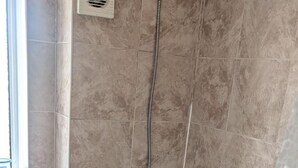 A bathroom with a bathtub, a toilet, and a window. - 3 bed House Upto 6 Adults (Tilbury)