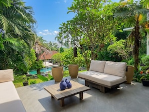A patio with a sofa, a coffee table, and potted plants. - Villa Athaya Pererenan by Beranda (Canggu)
