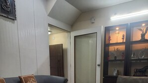 Una sala de estar con un sofá gris, una mesa de centro y un aparador con objetos decorativos.